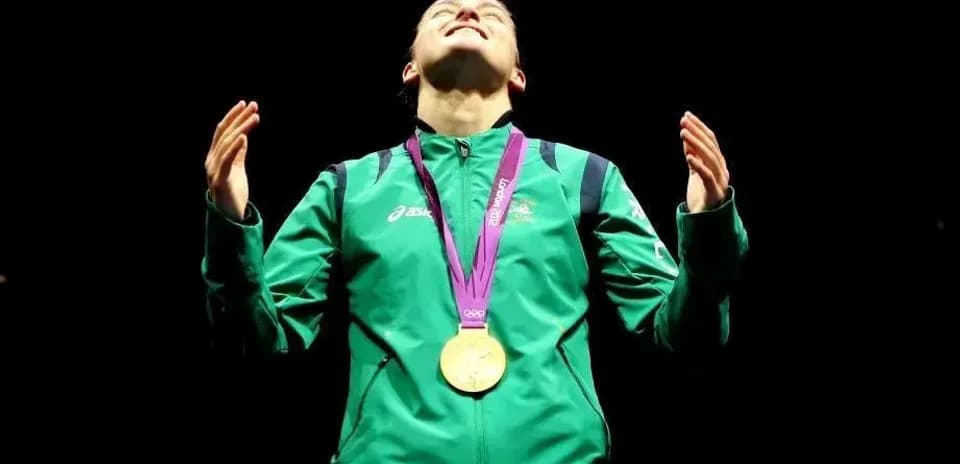 Athlete celebrating with gold medal in spotlight