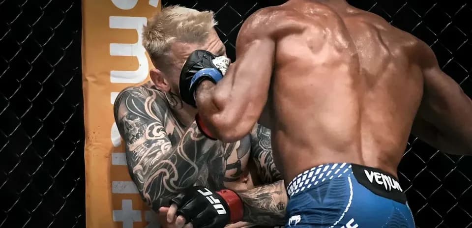 Two fighters engaged in close combat in the octagon