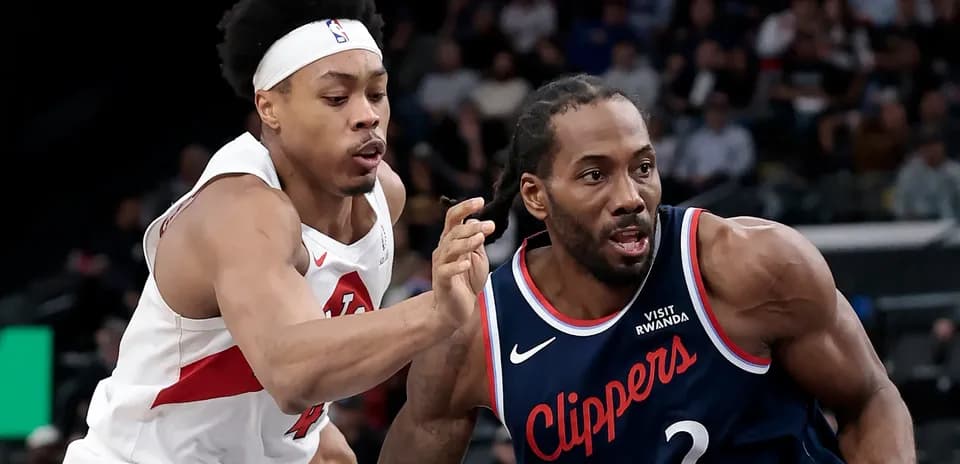 Two basketball players competing for possession of the ball