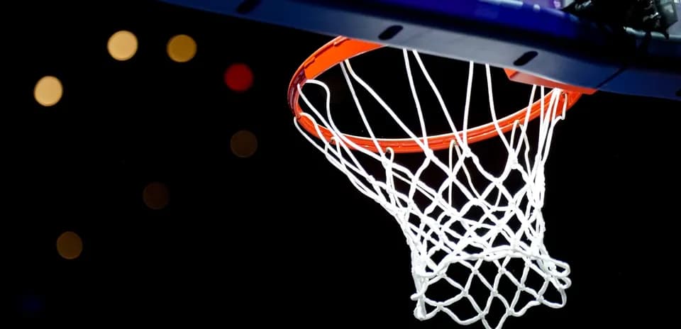 Basketball hoop with net against dark background