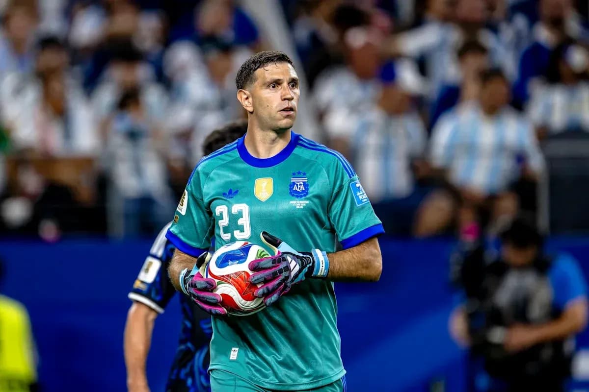 Goalkeeper in teal uniform holding a soccer ball