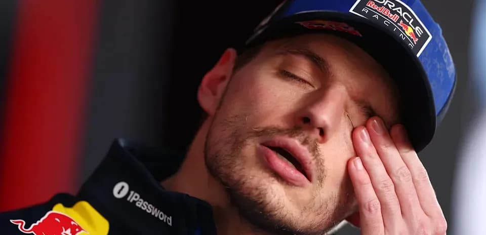 Driver resting with hand on face during press event