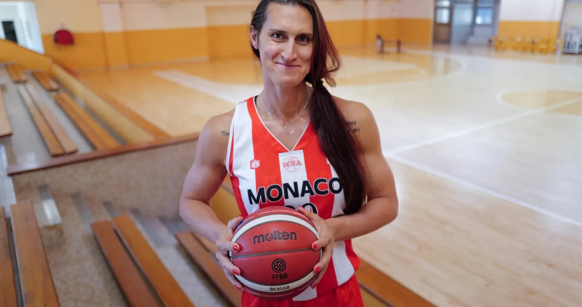 Player holding basketball in Monaco team uniform