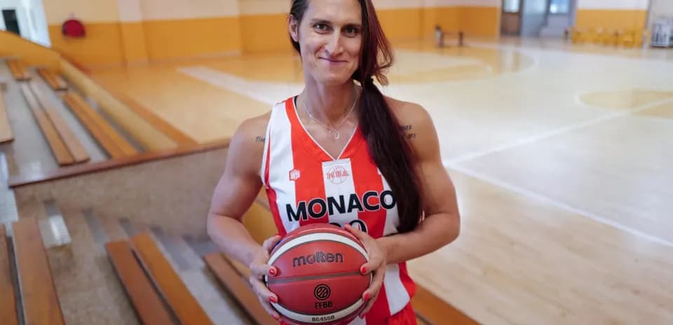 Player holding basketball in Monaco team uniform
