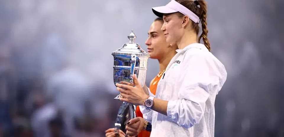 Two tennis players holding trophies after match