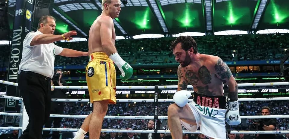 Boxers in ring during match with referee intervening
