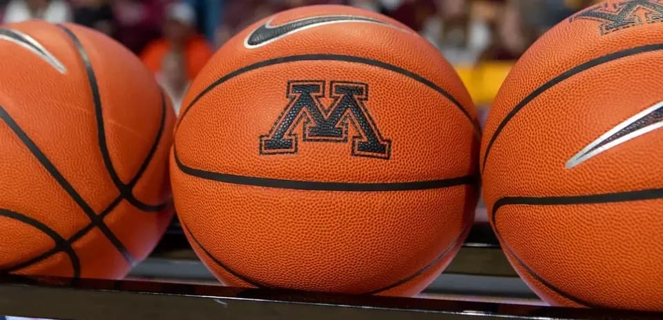 Three basketballs with Minnesota logo on bench