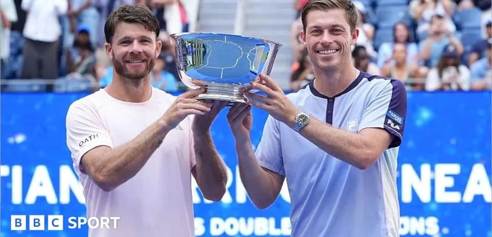 Two tennis players holding a trophy together