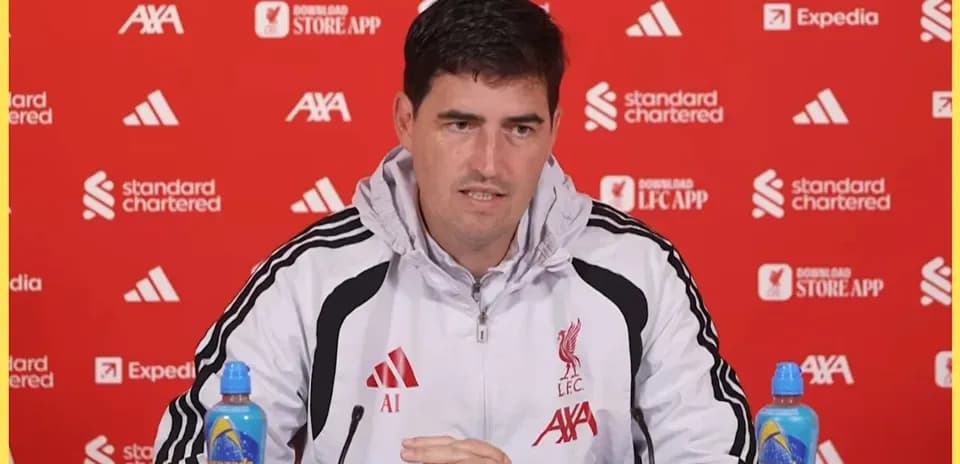 Manager speaking at press conference with Liverpool backdrop