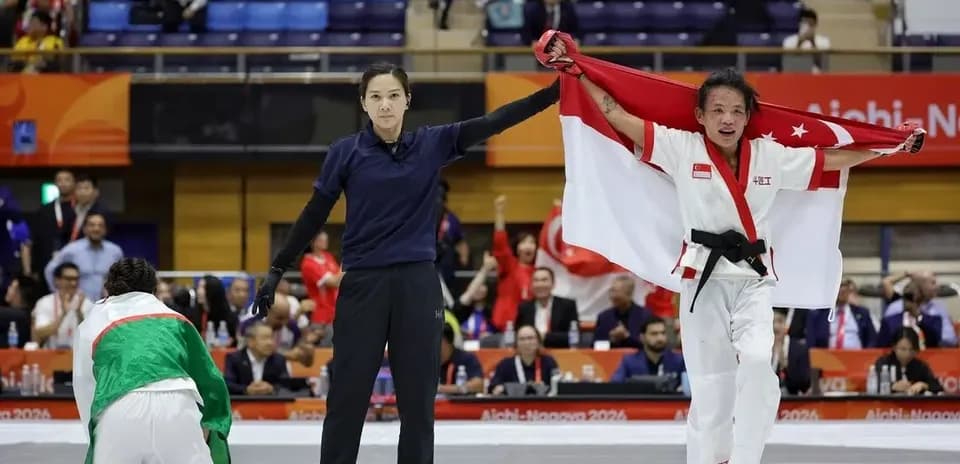 Athlete celebrating victory with Singapore flag raised