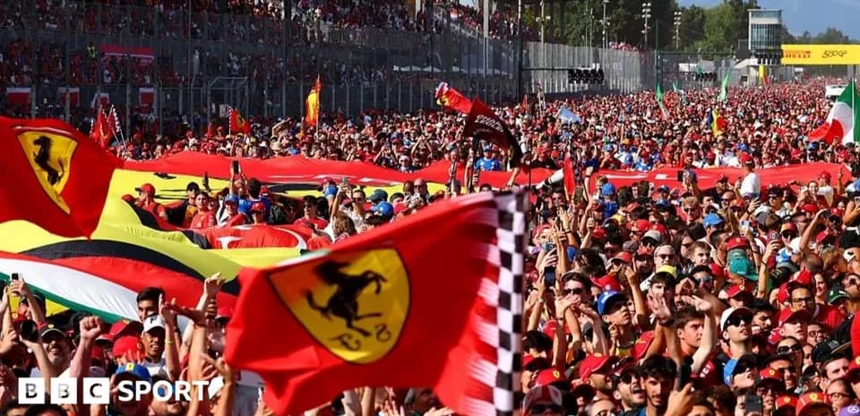 Crowd of Ferrari fans waving flags at event