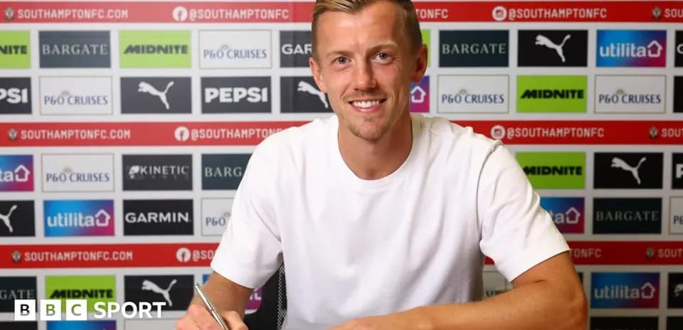 Player signing contract at press conference table