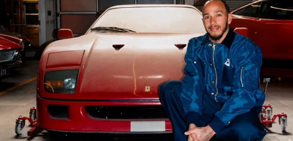 Man kneeling beside a red vintage car in garage