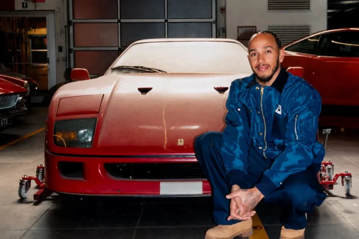 Man kneeling beside a red vintage car in garage