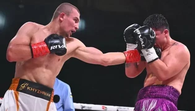Boxer delivering a punch to opponent in ring