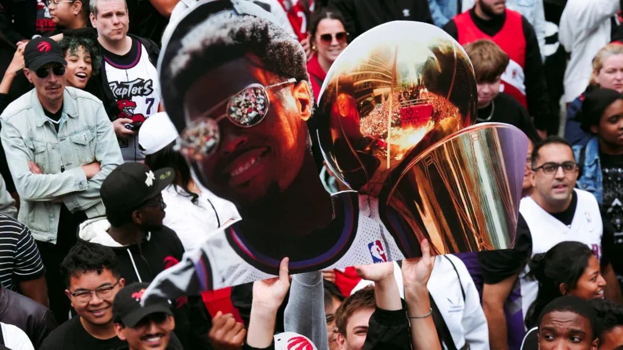 Fans holding a large cutout and trophy at celebration