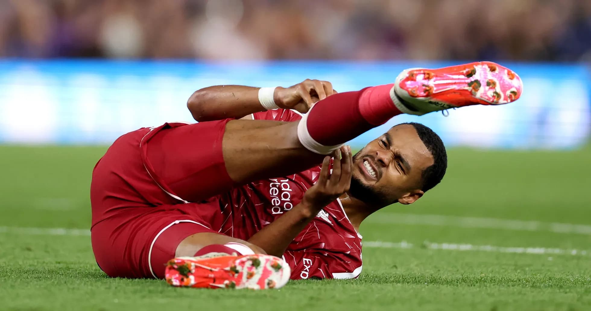 Player in red uniform lying on the pitch injured