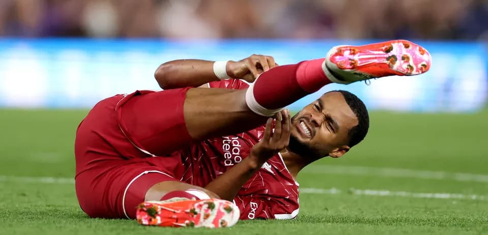 Player in red uniform lying on the pitch injured
