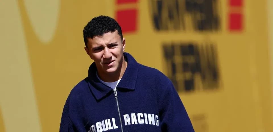 Young man in Red Bull Racing jacket walking outdoors