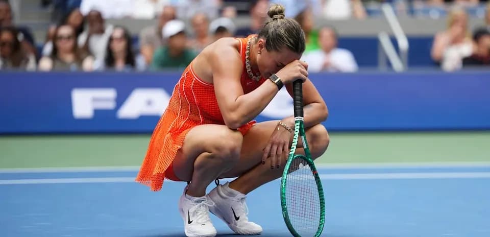 Player crouching on court holding racket during match
