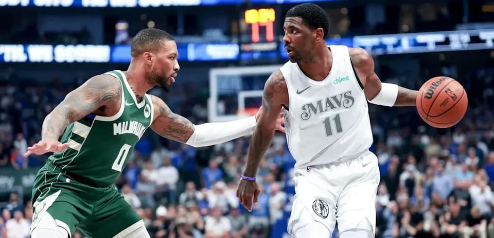 Two basketball players competing for possession of the ball