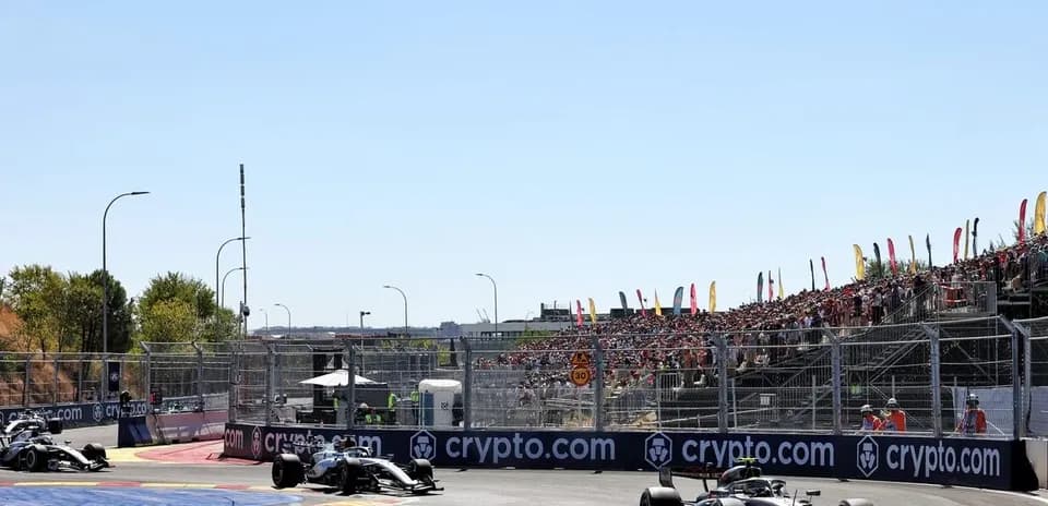 Formula 1 cars racing on circuit with spectators
