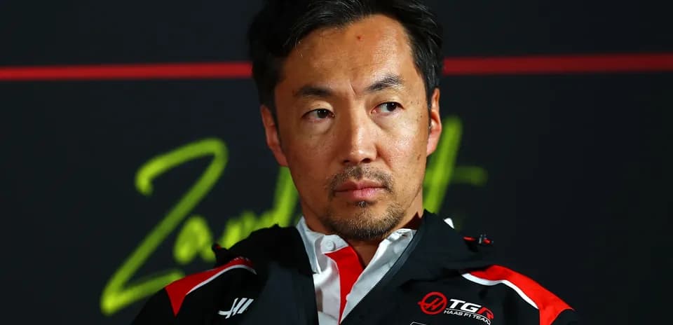 Man in team jacket during press conference