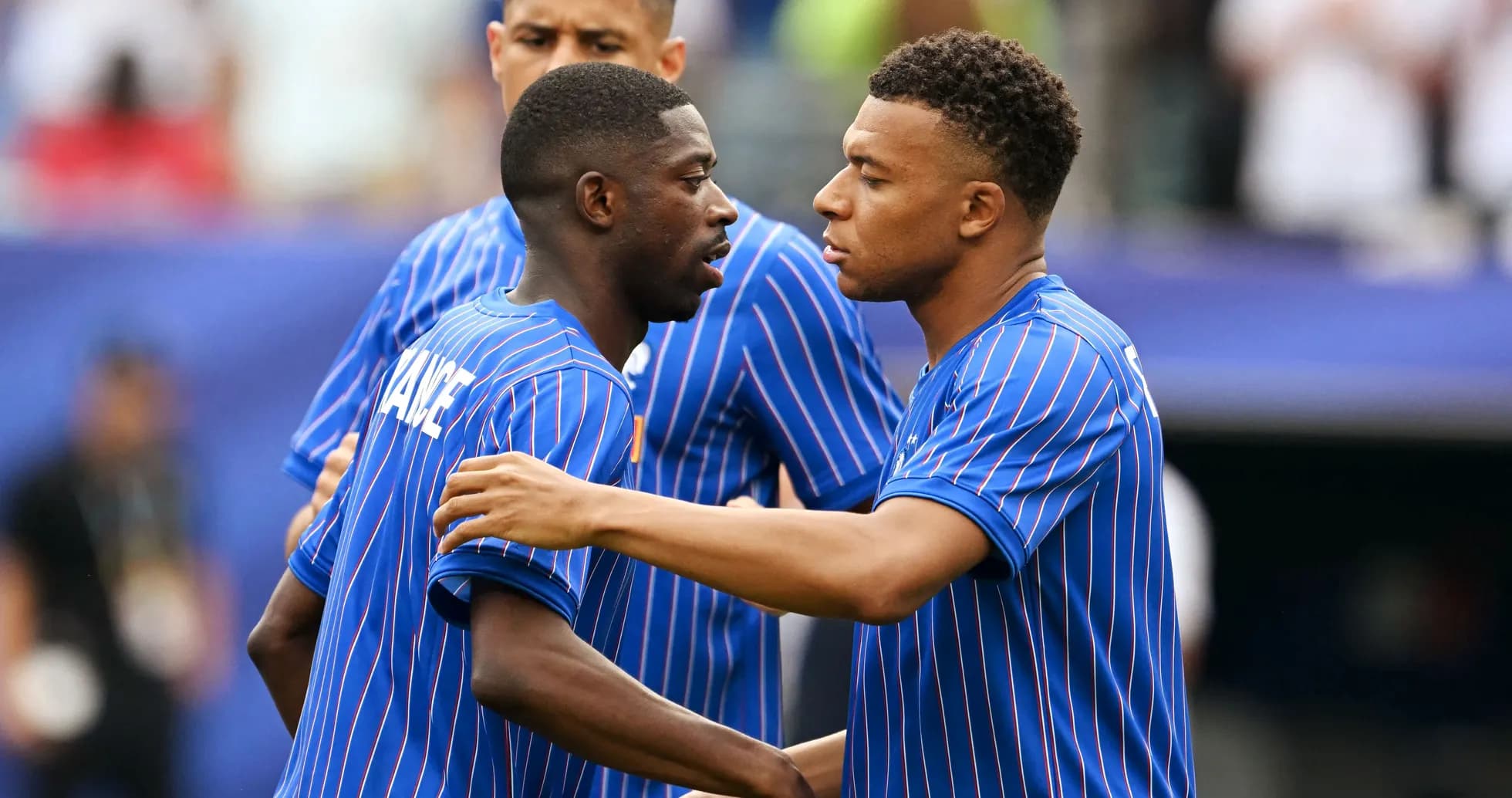 Two players in blue jerseys interacting on the field