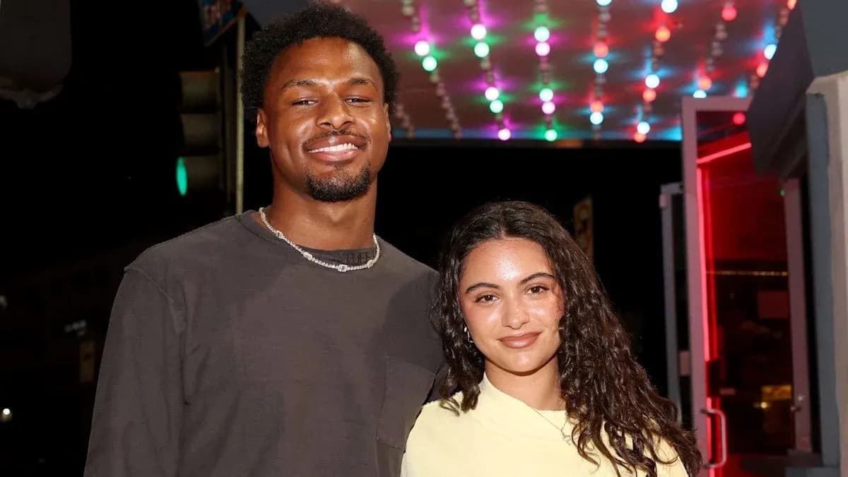 Two individuals posing together outside at night