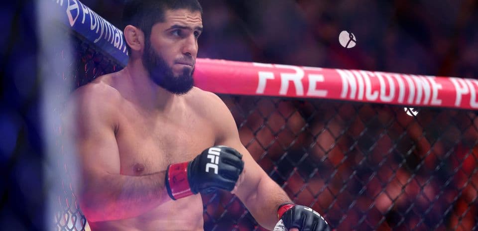 Fighter resting in corner of UFC octagon