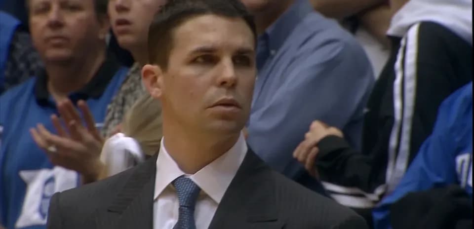 Coach observing game with fans in background