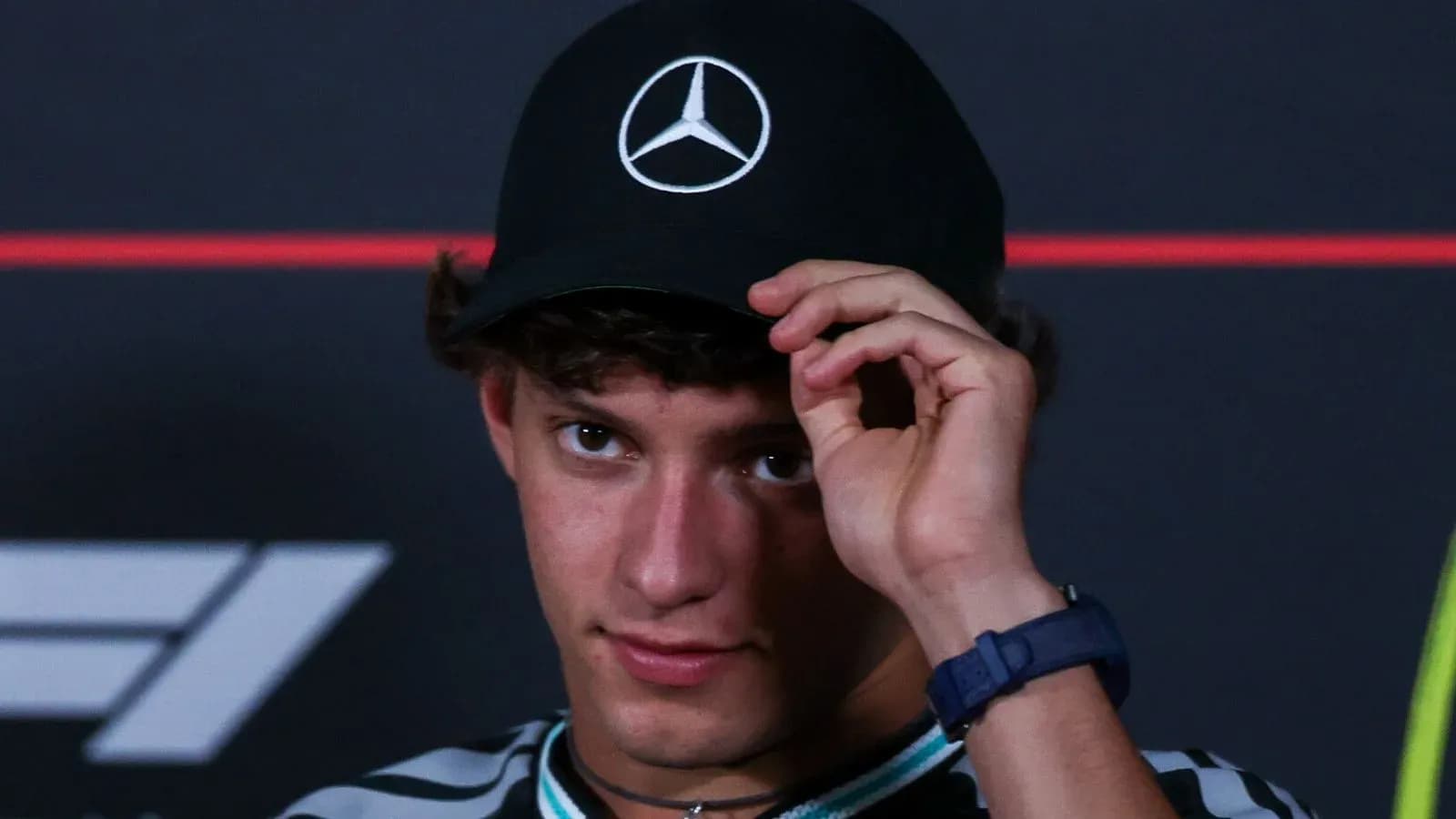 Young man adjusting his cap at press conference