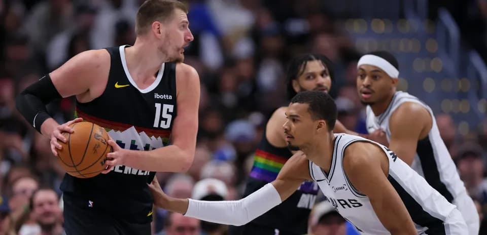 Player dribbling basketball while being defended
