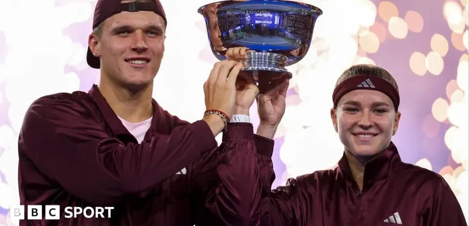 Two athletes celebrating victory by holding trophy