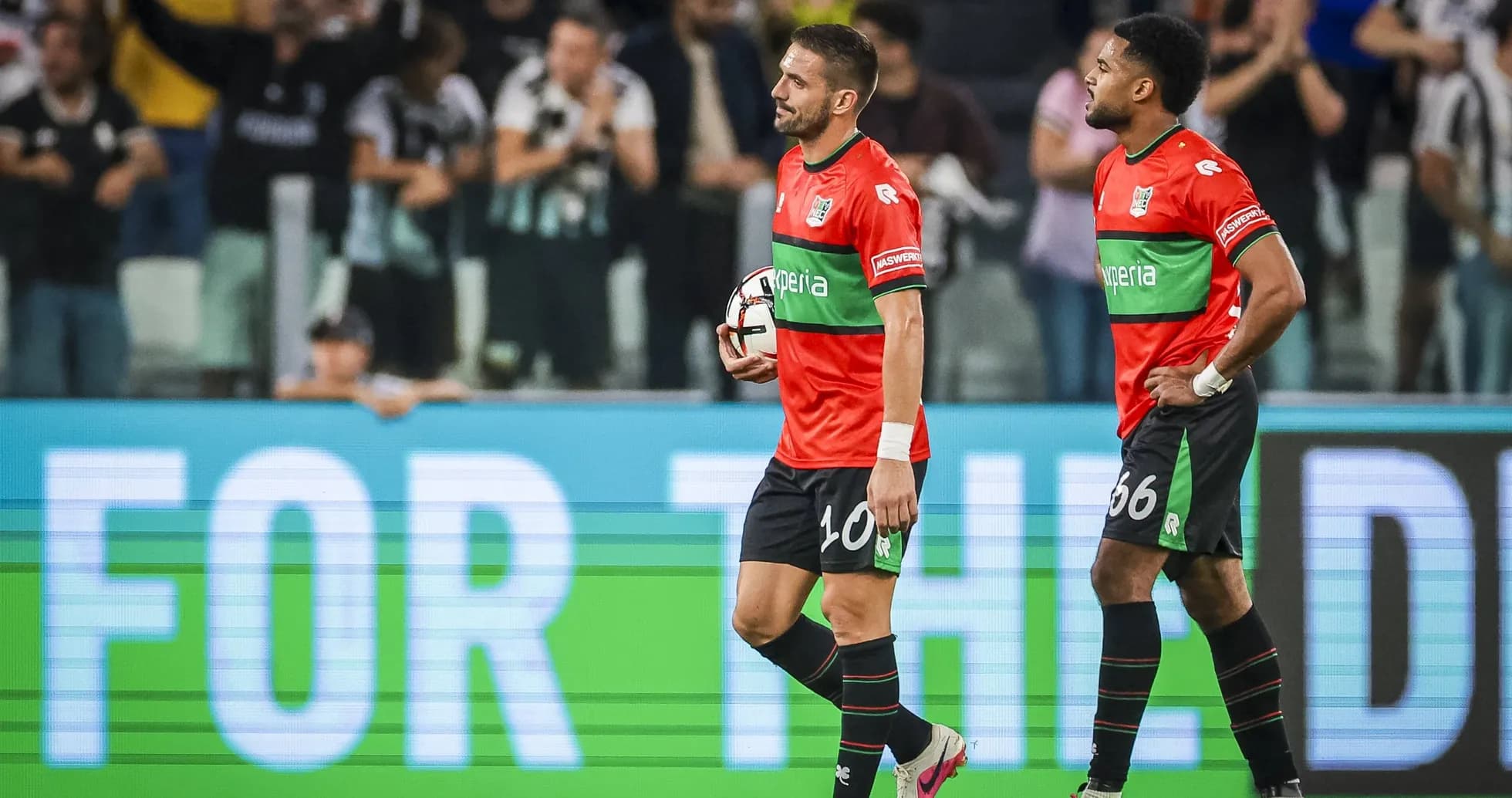 Two players walking off the pitch after match