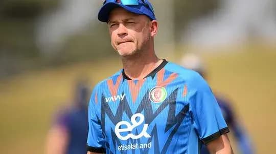 Cricket coach in training session attire on field
