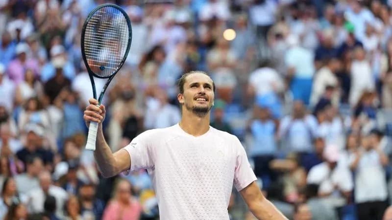 Tennis player celebrating in front of cheering crowd