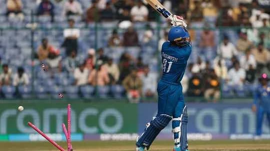 Batsman hitting the ball, stumps visible behind