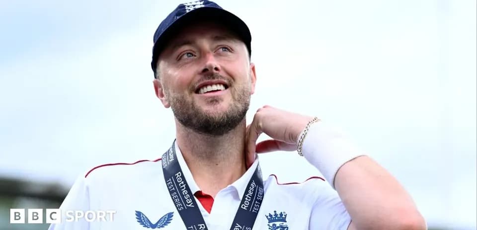 Cricketer wearing medal, smiling at the camera