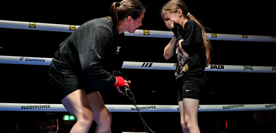 Boxer speaking to young girl in ring