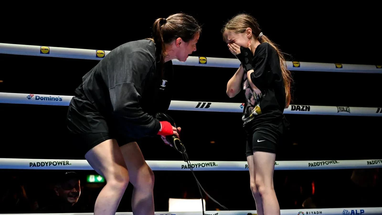 Boxer speaking to young girl in ring