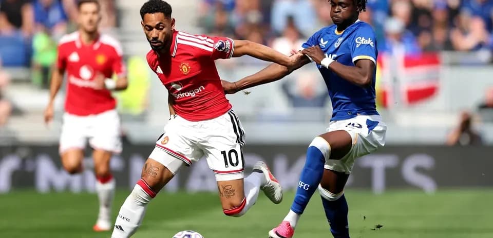 Player in red evading tackle during football match