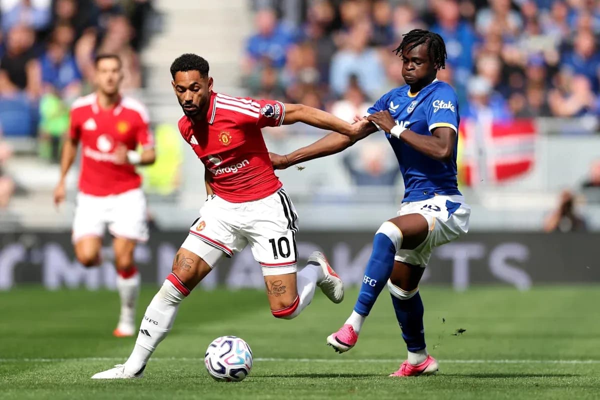 Player in red evading tackle during football match