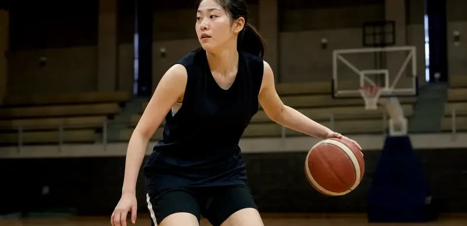 Female basketball player dribbling ball on court