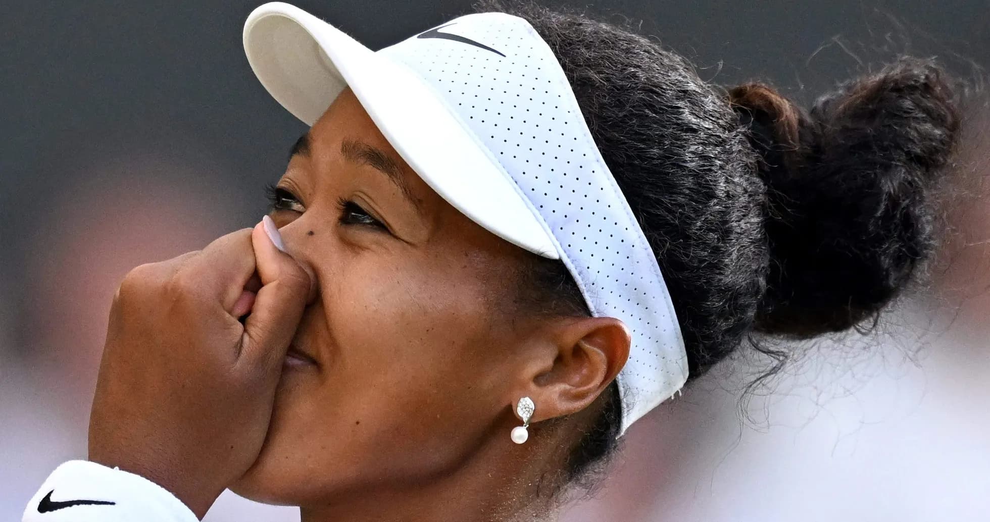 Tennis player celebrating victory with hand on face