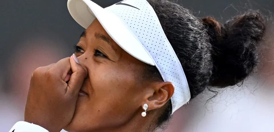 Tennis player celebrating victory with hand on face