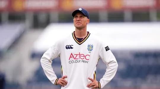 Cricketer wearing white kit looking up