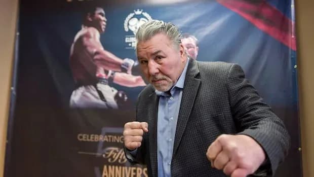 Man posing in boxing stance against promotional backdrop