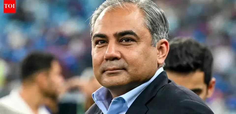 Person in suit at sports event with crowd behind