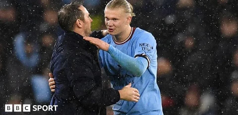 Player and coach embracing in the rain